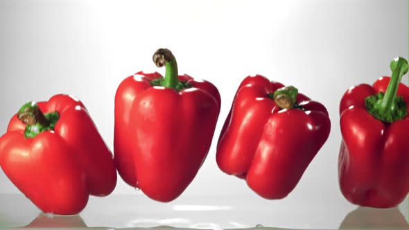 Super Slow Motion Red Bell Pepper Falls Into the Water with Splashes