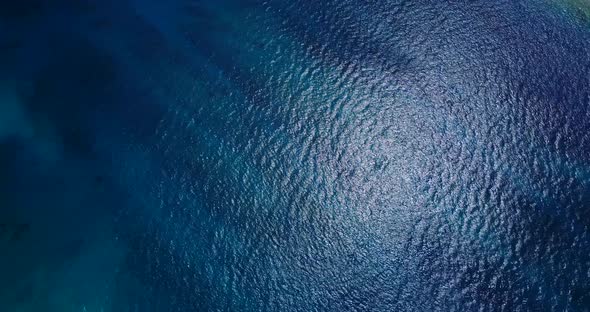 Wide aerial clean view of a sandy white paradise beach and aqua blue ocean background in hi res 4K