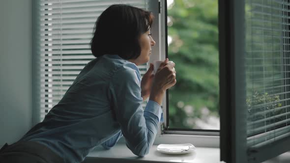 Woman Enjoying Rain During Coffee Break