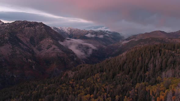 Aerial panning view of a colorful mountainside in the fall at sunset.