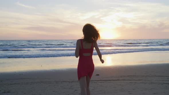 Girl running on the beach, at sunset