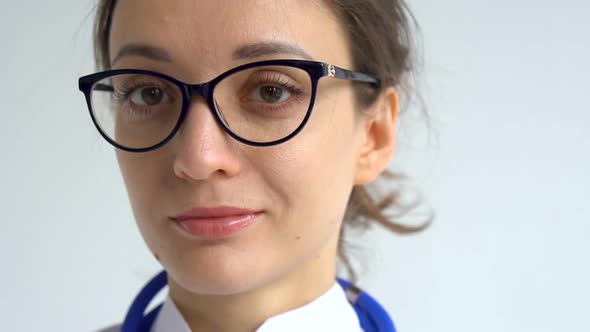 Female Doctor is Putting Off Protective Blue Gloves Isolated on White Background After Some Medical