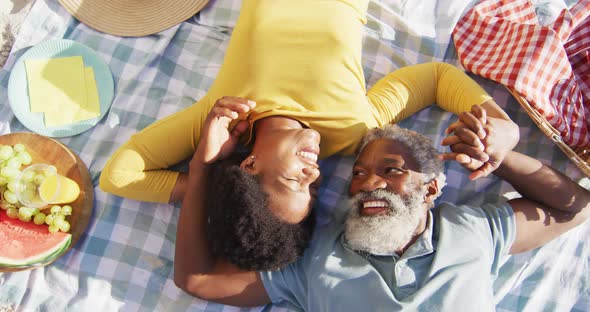 Happy african american couple having picnic on sunny beach