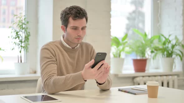 Attractive Man Using Smartphone in Office