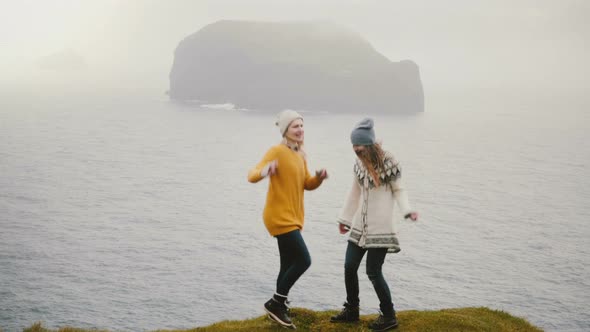 Two Crazy Happy Woman Standing on the Shore of a Sea and Dancing Together Tourists Having Fun in