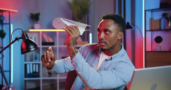 Black-Skinned Guy sitting at His Workplace in Home Office in the Evening