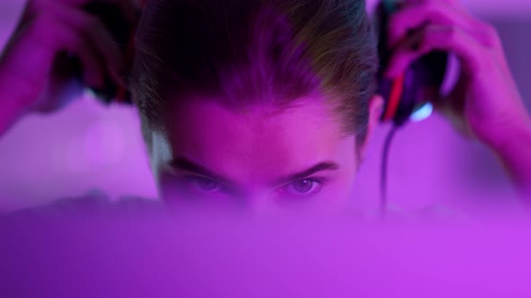 Esport Girl Wearing Cyber Headphones Before Round in Pink Neon Lights Closeup