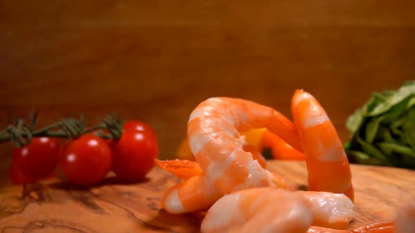 A Pile of Delicious Peeled Shrimps Is Falling on the Wooden Board