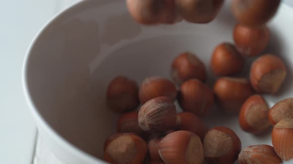 Camera follows chestnuts falling into a bowl. Slow Motion. alt