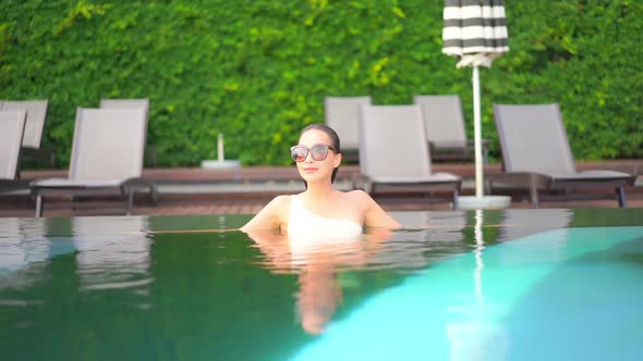 Young asian woman enjoy around outdoor swimming pool for leisure