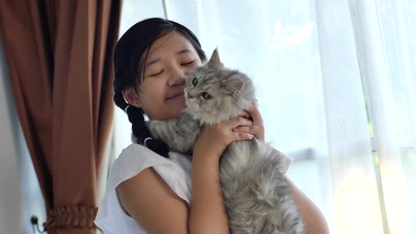 Asian Girl Kissing Persian Cat In Living Room