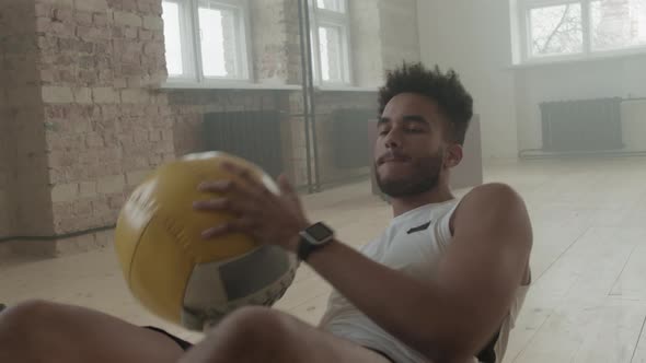 Afro Sportsman Doing Side Crunches With Weight Ball