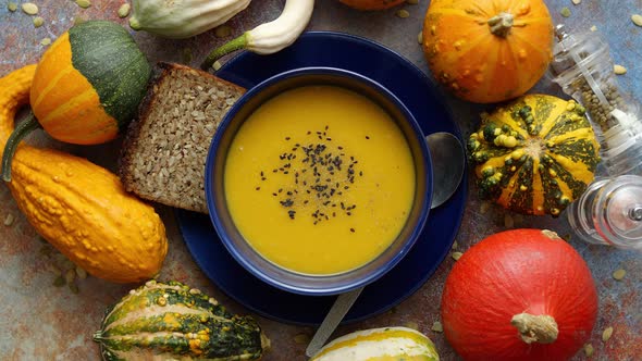 Compositon with Autumn Classic Food. Tasty Homemade Pumpkin Soup Decorated with Black Seed