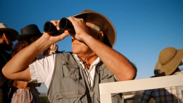 Friends looking through binoculars during safari vacation 4k