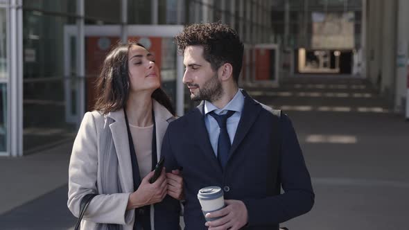 Happy business couple leaning on each other in the city