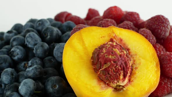 Assorted fruits and berries on a white background rotation 360. Summer fruit raspberry blueberry