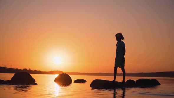Boy resting in pond. Silhouette a boy with rocket paper in the sunset