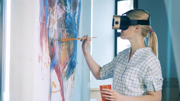 Blond Lady is Using a Brush and VRglasses for Painting