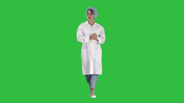 Friendly female doctor walking and talking to camera on