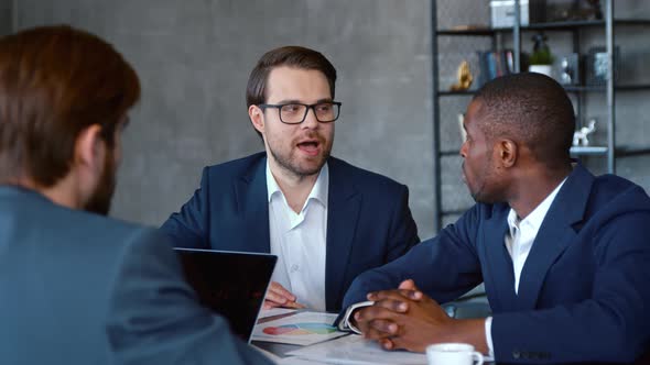 Business colleagues in suits discussing at a meeting