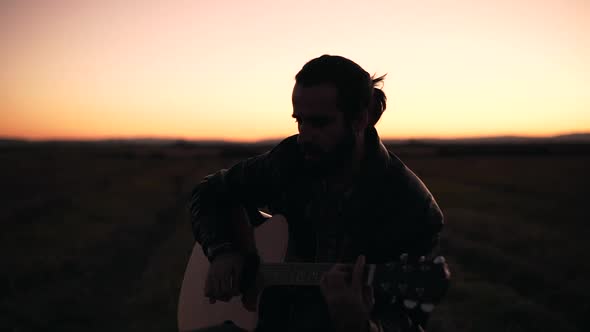 Man playing guitar in a meadow