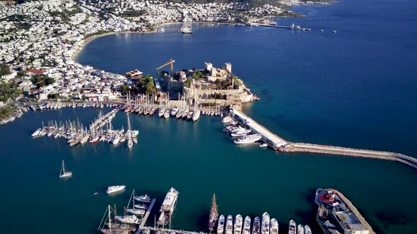 View from drone on full of yachts Bodrum harbour and ancient Kalesi castle in Mugla in Turkey