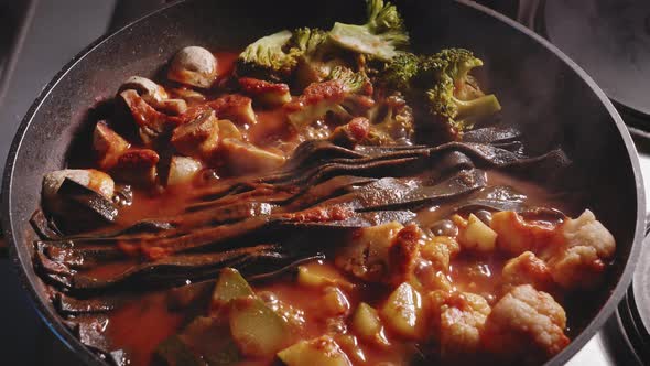 Noodles, Vegetables and Chicken Breast is Simmering in Sauce in the Pan