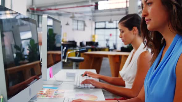 Female business executives working over computer