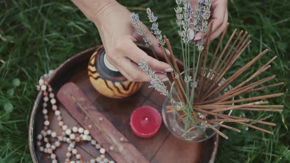 Closeup of Aroma Sticks,candles and Lavender in a Bottle on a Wooden Plate on the Grass