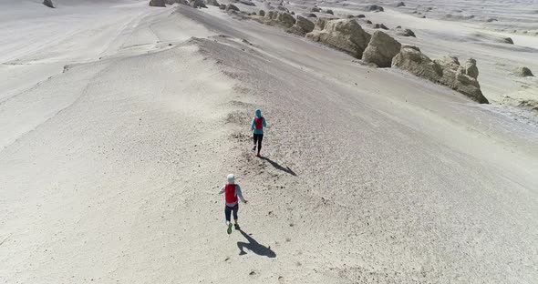 Two women trail runners cross country running in the desert 