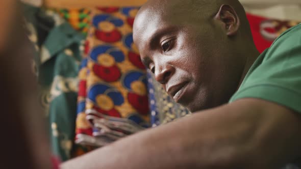 African man focused sewing