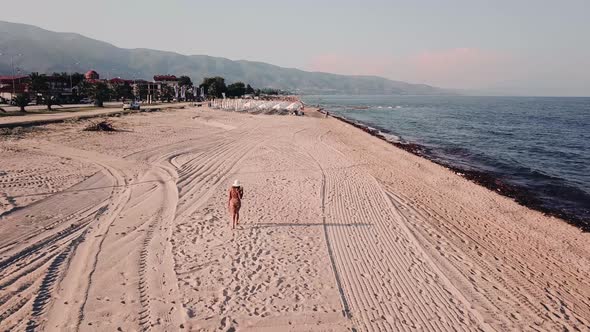 Girl walking alone at the beach in Greece