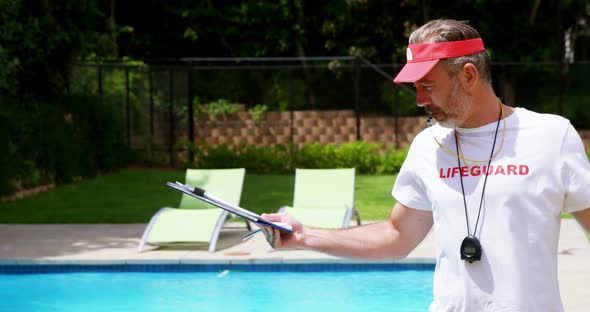 Lifeguard holding clipboard and whistling