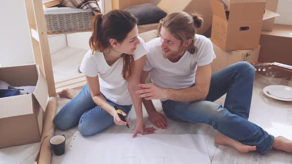 Cool Caucasian Pair Happily Planning Their Life in New Flat