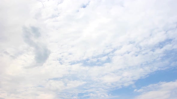 Movement of cumulus continuous clouds on a blue beautiful sky, background in motion, accelerated