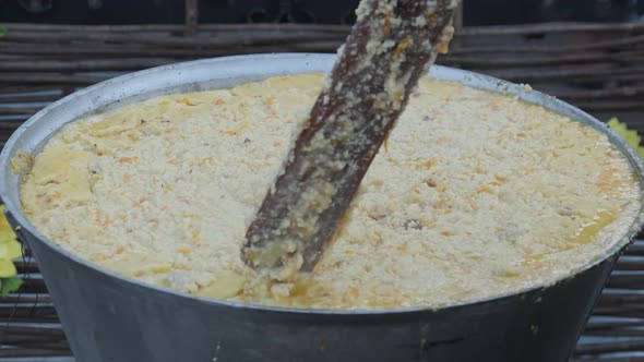 The Cook Prepares Wheat Porridge in a Traditional Large Cauldron. Street Food