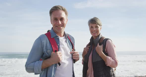 Portrait of Caucasian couple enjoying free time by the sea on sunny day