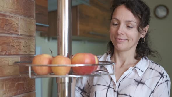 Woman in the kitchen spread apples.