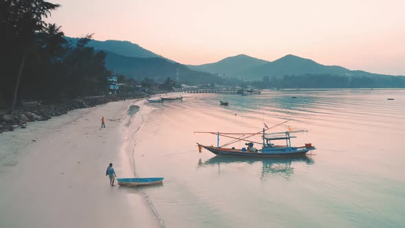 Morning Ocean Beach with Fishing Boats in Sunrise Pink Light