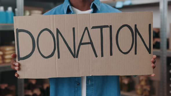 Close Up of African American Male Volunteer Holding Donation Banner