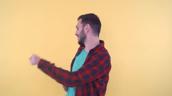 Joyful Young Man Dancing Moving Arms and Body in Studio