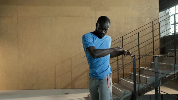 Fit man in sport clothes warming up before running on stairs