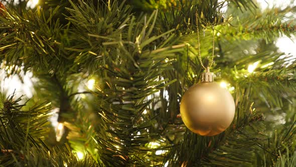 Decorative golden bauble on  the artificial tree close-up  4K 2160p 30fps UltraHD footage - Christma