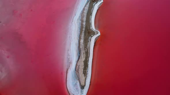 Epic Drone Flight Over Beautiful Pink Salt Lake with Deep Colorful Calm Water Surface and Small