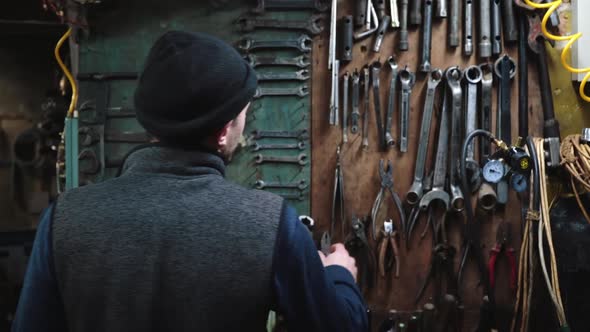 Man Taking Wrench at Garage