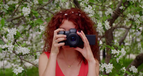 Woman Taking Pictures in a Blooming Park