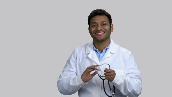 Young Darkskinned Doctor Puts on Stethoscope and Listening