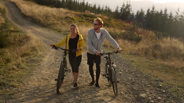 Cyclists with Bicycles Walking on Road