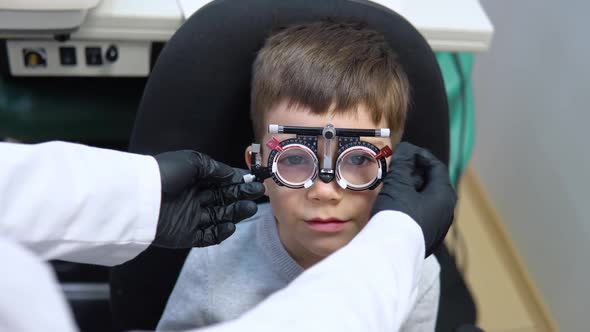 A Boy Sits in a Chair at an Ophthalmologist's Appointment to Pick Up Contact Lenses