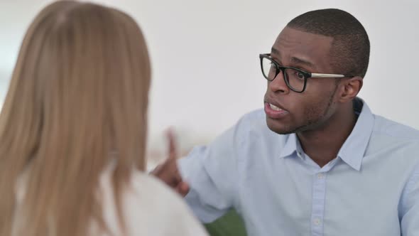 Rear View of Mixed Race Couple Having Conversation on Sofa